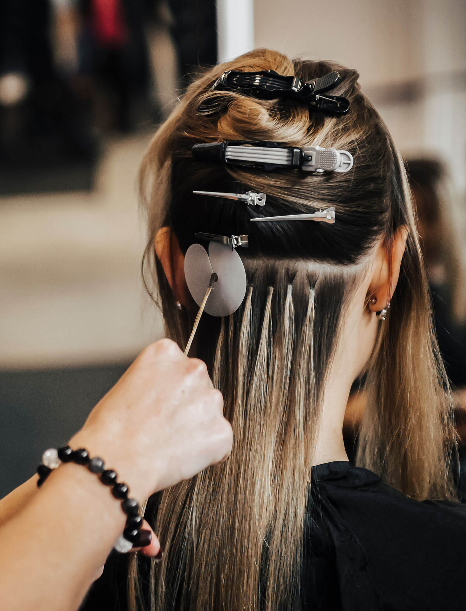 Extension per capelli - donna da dietro con mollette da parrucchiere tra i capelli - Haarstudio Mayr a Brunico