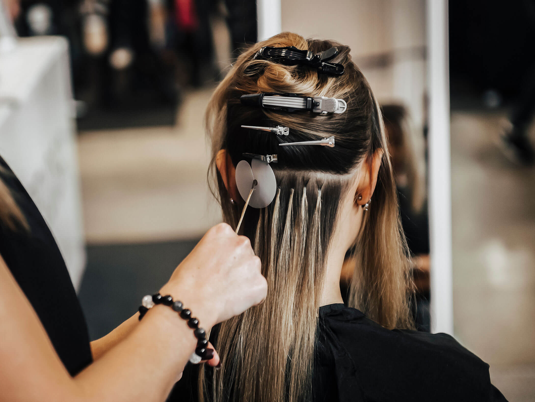 Parrucchiere esegue un'extension su una donna - Haarstudio Mayr a Brunico