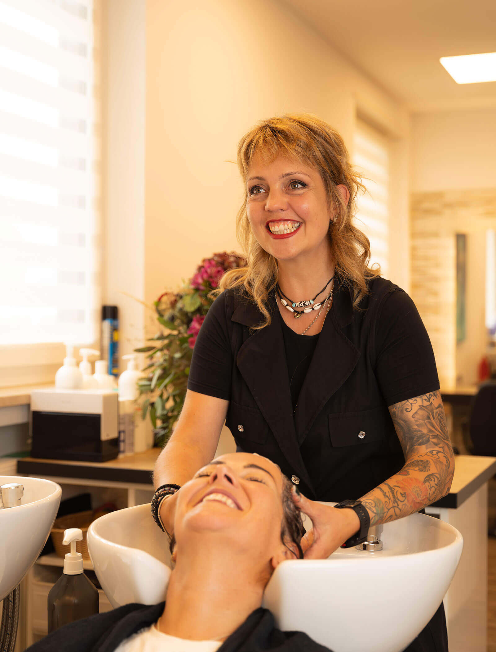 Impiegato - donna lava i capelli di un cliente - Haarstudio Mayr a Brunico