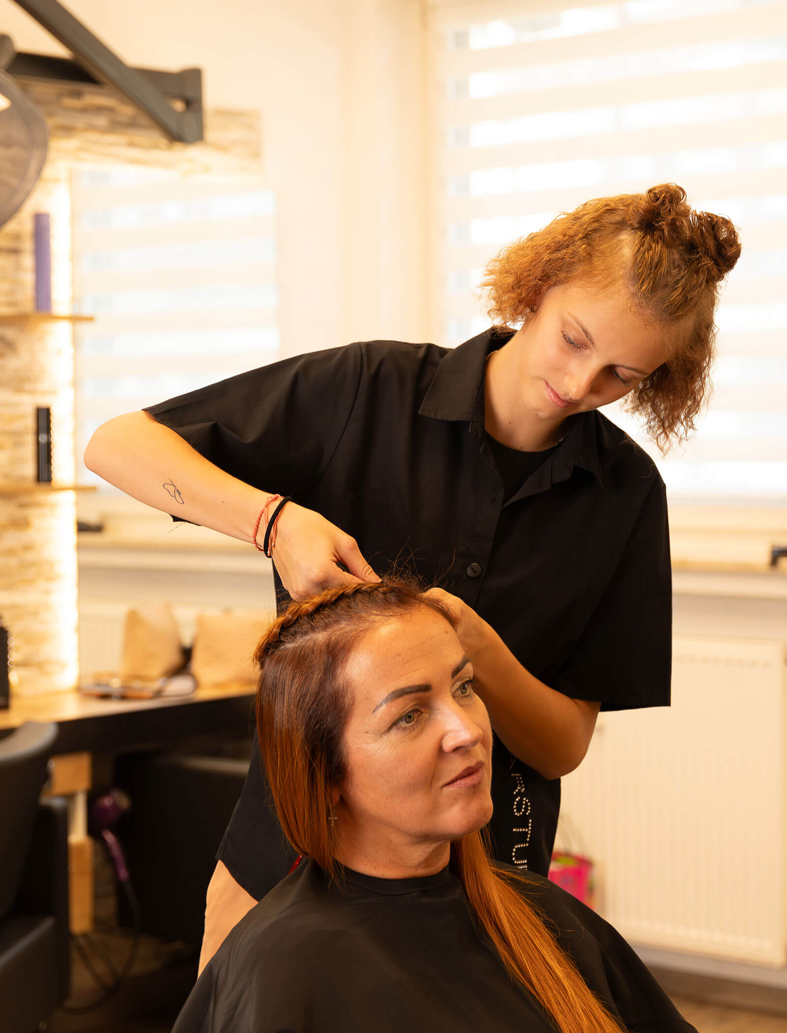 Impiegato - donna che acconcia i capelli di un cliente - Haarstudio Mayr a Brunico