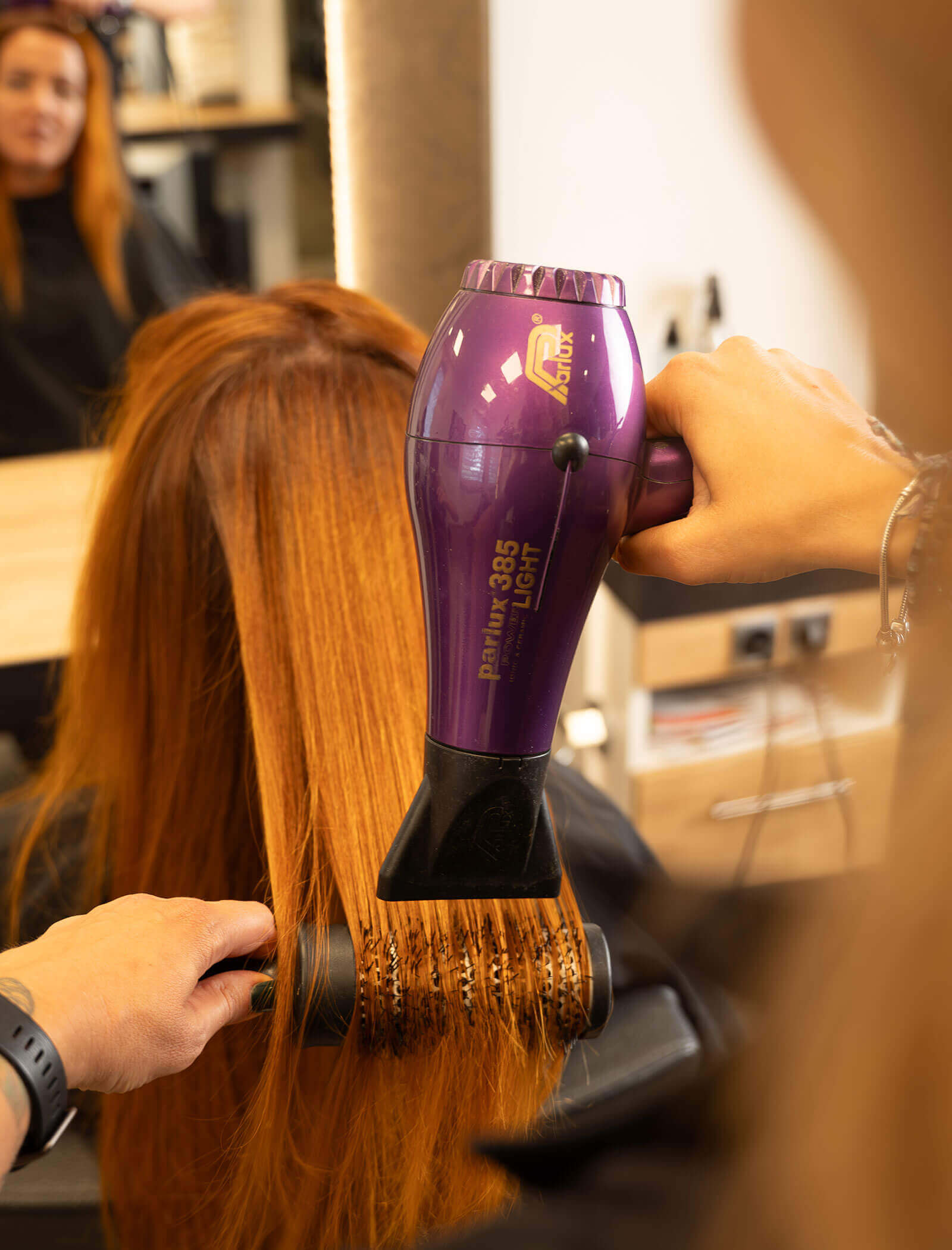 Parrucchiere che asciuga i capelli arancioni di una donna - Haarstudio Mayr a Brunico